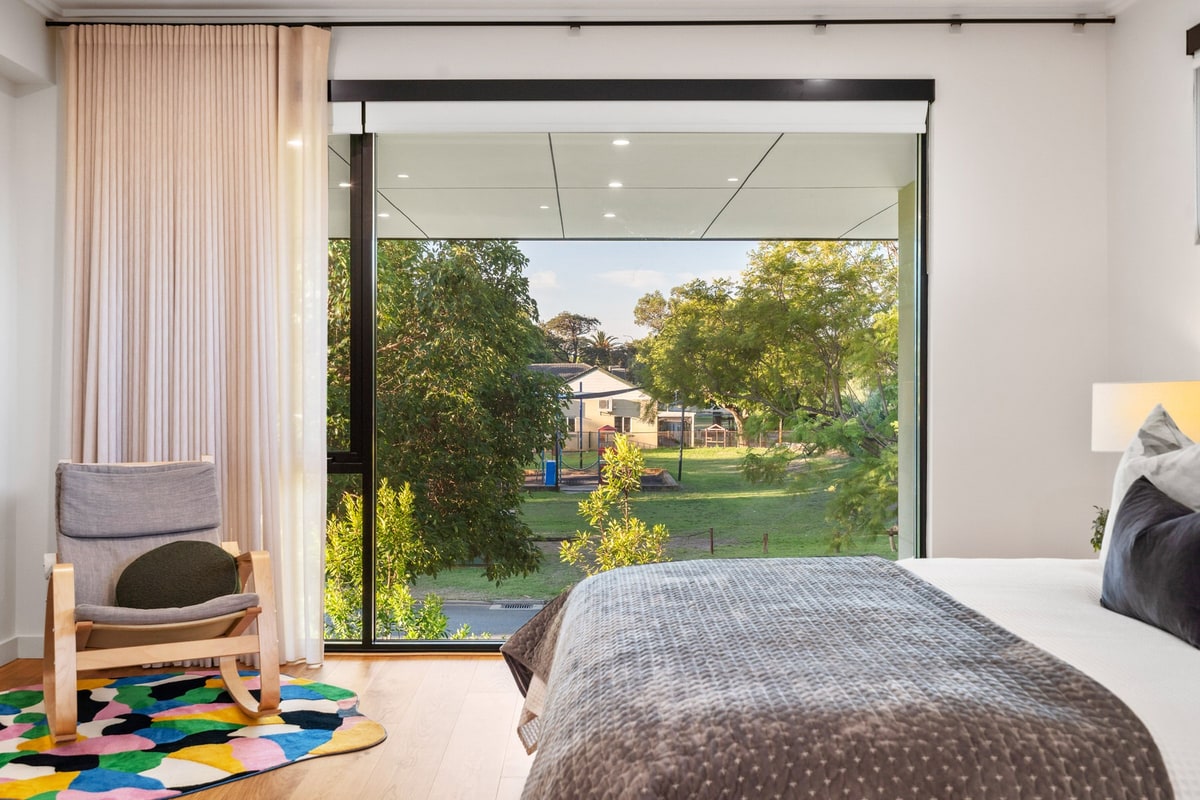 Bedroom in a Norde Homes home with sliding doors open to the garden